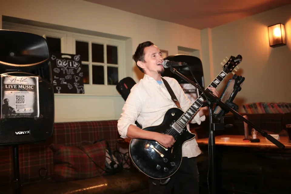 AntZ playing guitar at The Hare